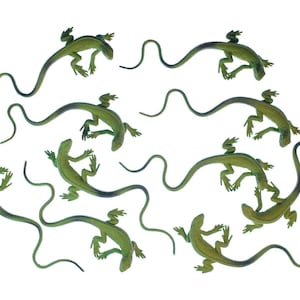 Puede incluir: Una colección de nueve pequeñas figuras de lagartos verdes dispuestas en varias poses. Cada lagarto de plástico presenta un cuerpo texturizado, cuatro patas y una cola larga, delgada y curva. Las figuras son de tonos verdes.