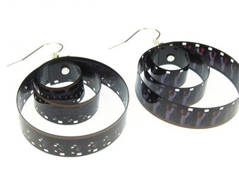 Peut inclure: Une paire de boucles d'oreilles en forme de spirale, réalisées à partir de bandes de pellicule noire et argentée.