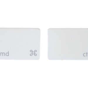 May include: Two white computer keyboard keys. One key has the text "cmd" and a symbol, the other key has the text "ctrl". The keys are rectangular with rounded corners and are set against a white background.