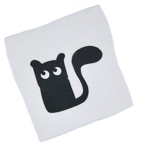 May include: White wristband with a black cat design. The cat has large eyes and a long tail.
