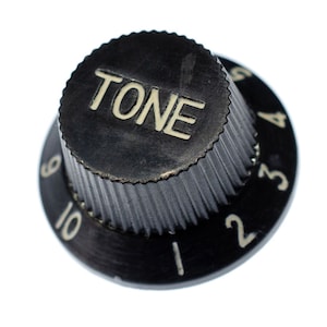 May include: Black plastic guitar knob with the word "TONE" printed in white on the top and numbers 1 through 10 printed around the edge.