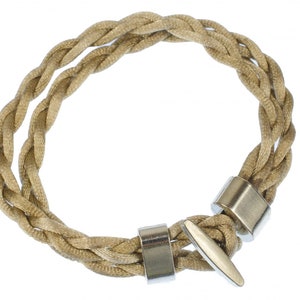 May include: A braided beige fabric bracelet with silver metal clasps.