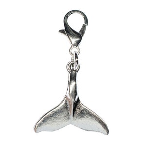 May include: Silver whale tail charm with a lobster clasp. The tail is detailed and realistic.