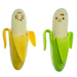 Könnte beinhalten: Zwei gelbe und grüne bananenförmige Radiergummis mit gezeichneten lächelnden Gesichtern. Die Radiergummis sind aus weichem, biegsamem Material gefertigt und perfekt für die Schule oder das Büro.