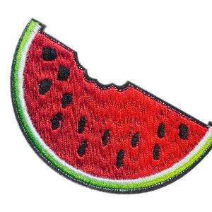 Könnte beinhalten: Eine rote Wassermelone Scheibe mit schwarzen Kernen und einer grünen Schale. Die Wassermelone ist auf einem Stoff-Patch gestickt.