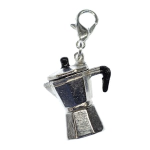 Könnte beinhalten: Silberner Anhänger in Form einer traditionellen italienischen Kaffeekanne mit schwarzem Griff und silbernem Haken.