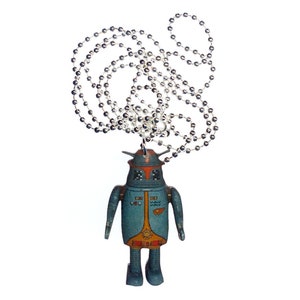 Könnte beinhalten: Eine silberne Kettenkette mit einem blauen und orangefarbenen Roboter-Anhänger. Der Roboter hat einen silbernen Helm und eine silberne Kette, die an der Oberseite seines Kopfes befestigt ist.