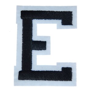 Peut inclure: Écusson brodé noir en forme de lettre "E" sur fond blanc. La lettre est de style bloc avec une bordure épaisse et cousue. L'écusson est probablement destiné à être appliqué sur des vêtements ou des accessoires.