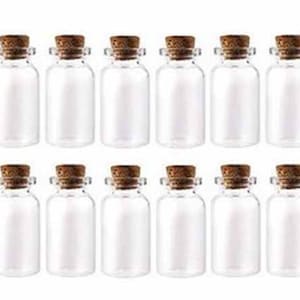 Peut inclure: Dix bouteilles en verre transparent avec des bouchons en liège. Les bouteilles sont toutes de la même taille et de la même forme, et elles sont disposées en deux rangées de cinq.