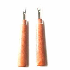 Op de afbeelding: Twee naaldverwijderaars met houten handvatten en metalen bladen. De naaldverwijderaars zijn bruin en hebben een natuurlijke houtnerf.