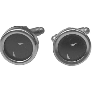 May include: A pair of silver cufflinks with black enamel and white accents. The cufflinks are round and have a simple design.