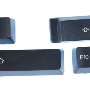 May include: Four black computer keys with white lettering. The keys are for the numbers 1 and 10, the exclamation point, and the up arrow.
