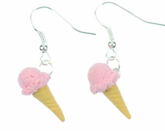 May include: A pair of silver dangle earrings with pink and beige ice cream cone charms.