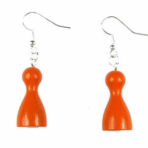 Puede incluir: Un par de pendientes de madera naranja con forma de bolos con ganchos plateados.