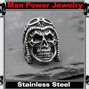 May include: Stainless steel skull ring with a pilot helmet design. The ring features a detailed skull face with goggles and intricate metalwork. The text "Man Power Jewelry" and "Stainless Steel" are displayed.
