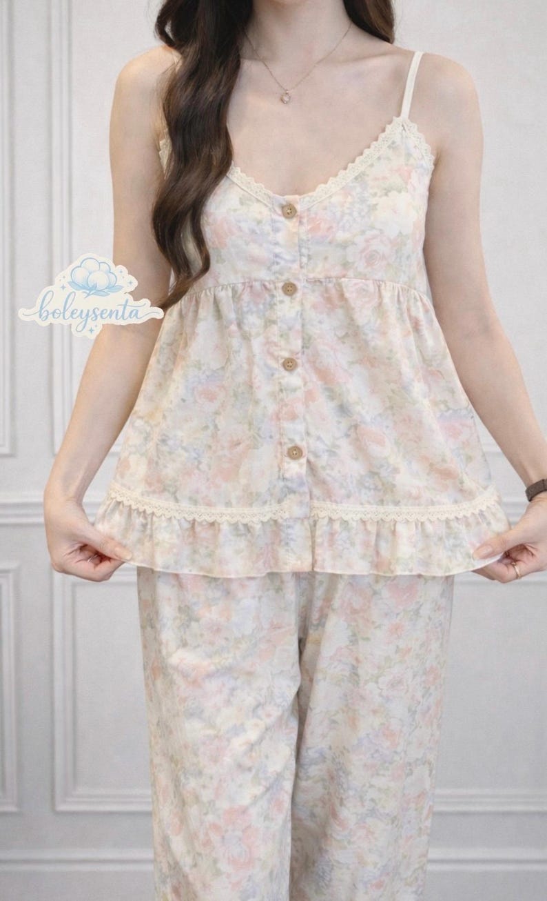 May include: Floral print pajama set in soft pastel colors. The camisole top features a V-neckline with lace trim and wooden buttons. The matching pants complete the set. The brand name "boleysenta" is visible in the image.