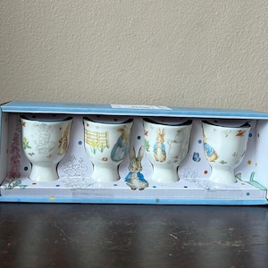 May include: A set of three ceramic mugs with a speckled, matte finish. The mugs are in shades of cream, light gray, and dark gray. Each mug has a simple, minimalist design, perfect for coffee or tea.