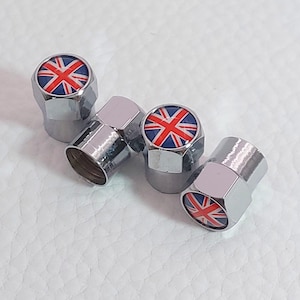 May include: Four chrome-colored tire valve stem caps. Each cap features a Union Jack design with red, white, and blue colors. The caps are hexagonal in shape and are arranged on a white surface.