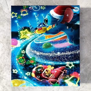 K&ouml;nnte beinhalten: Adventskalender mit einem blauen Zeichentrickcharakter mit Weihnachtsm&uuml;tze, vor einem sternenklaren Nachthimmel. Der Kalender hat nummerierte T&uuml;ren von 1 bis 24, mit weihnachtlichen Illustrationen und einer roten Rakete.