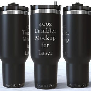 Op de afbeelding: Drie zwarte bekers van 1183 ml met handvatten en zilveren accenten worden getoond. De tekst "40oz Tumbler Mockup for Laser" staat op de middelste beker. De bekers zijn ontworpen voor lasergravure.