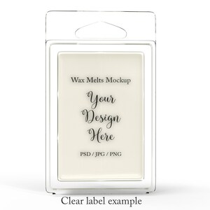 May include: Clear plastic packaging containing a rectangular wax melt. The label reads "Wax Melts Mockup" with the text "Your Design Here" in a script font. The bottom of the label says "PSD / JPG / PNG". The words "Clear label example" are at the bottom.