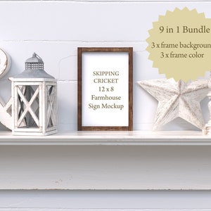 Puede incluir: Una repisa de chimenea de estilo farmhouse blanca con una maqueta de marco de madera. El marco mide 30,5 cm por 20,3 cm y tiene el texto "Skipping Cricket Farmhouse Sign Mockup". La repisa está decorada con una linterna blanca, una estrella de madera blanca y dos candelabros blancos.