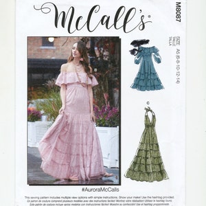 May include: A sewing pattern for a maxi dress with multiple views. The pattern includes instructions for making a dress with a halter neckline and a dress with an off-the-shoulder neckline. The pattern is for sizes 6-8-10-12-14. The pattern is from McCall's and the hashtag #AuroraMcCalls is included.