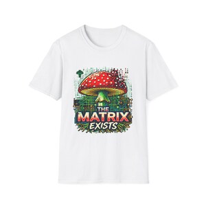 Könnte beinhalten: Ein weißes Kurzarm-T-Shirt mit einer Grafik eines roten Pilzes mit weißen Punkten, der in ein digitales Schaltkreis-Muster mit Binärcode integriert ist. Der Text THE MATRIX EXISTS ist in fetten Buchstaben unter dem Pilzhut gedruckt.