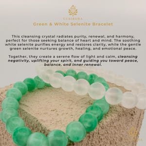 May include: Two bracelets with green and white selenite beads. The bracelets are displayed on a textured surface. The text "Green & White Selenite Bracelet" is visible. The bracelets are for balance and inner renewal.