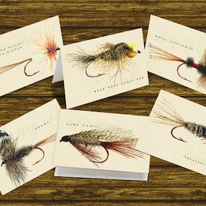 May include: Set of ten illustrated fly fishing cards with the names of different flies, including "Western Mackrel Brown Biot", "Royal Coachman", "Adams", "Dark Cahill", and "Pheasant Tail".