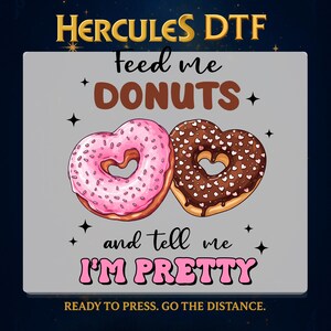 May include: A graphic featuring two heart-shaped donuts, one pink and one chocolate, with the text "Feed me DONUTS and tell me I'M PRETTY." The image includes the text "HERCULES DTF" and "READY TO PRESS. GO THE DISTANCE."