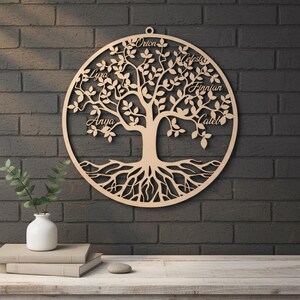 Peut inclure: Une œuvre d'art murale en bois représentant un arbre généalogique. L'arbre est découpé au laser avec un cadre circulaire, présentant un motif d'arbre détaillé avec des racines, des branches et des feuilles. Les noms sont inscrits sur les feuilles. Les noms sont : Anya, Lyra, Orion, Celeste, Finnian et Caleb.