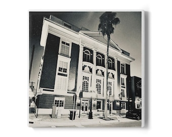 May include: Black and white photograph of a large building with columns and multiple windows. A palm tree stands to the right of the building. The image is a square print.