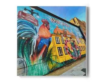 May include: A vibrant mural on a wall featuring a colorful rooster, a yellow building, and the text "VIVA YBOR." The artwork includes an American flag and the words "SUNDAYS DELICATESSEN."