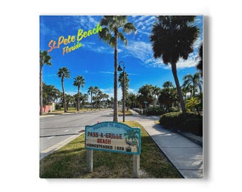 May include: A square canvas print featuring a street scene in St. Pete Beach, Florida. The image shows palm trees, a blue sky, and a sign that reads "Pass-A-Grille Beach, Homesteaded 1886."