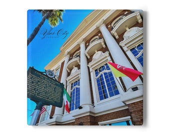 May include: A square canvas print featuring a building with large white columns and arched windows under a bright blue sky. The image includes flags and a sign that reads "L'UNIONE ITALIANA". The words "Ybor City, Florida" are also visible.