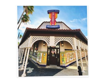 May include: Exterior view of the Columbia Restaurant, a historic establishment. The building features a Spanish-style facade with arched openings, decorative tiles, and a sign that reads "Columbia Restaurant Since 1905."