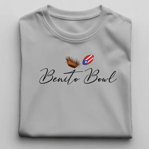 Op de afbeelding: Een lichtgrijs t-shirt met de woorden "Benito Bowl" in een sierlijk lettertype. Het shirt heeft een afbeelding van een kokosnoot, een Puerto Ricaanse vlag en een kokosnootschil.