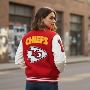 May include: A red and white letterman jacket with the word "CHIEFS" in yellow block letters across the back. The jacket features white sleeves and a team logo patch. The number "1" is on the left sleeve.