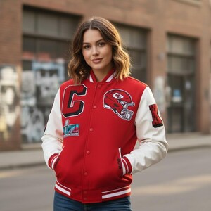 May include: Red and white varsity jacket with a snap-button closure. The jacket features a large "C" patch, a football helmet graphic, and a "Super Bowl" patch. The sleeves are white, and the jacket has red and white striped cuffs and hem.