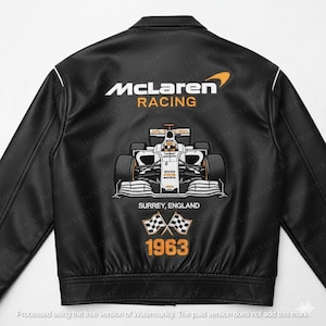 Può includere: Giacca in pelle nera con il logo McLaren Racing e una grafica di auto di Formula 1. Il retro della giacca mostra il testo "McLaren Racing", "Surrey, England" e l'anno "1963". Rifiniture bianche accentuano il colletto e le maniche.