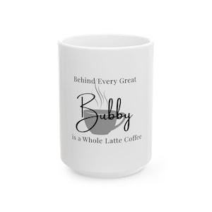 May include: White ceramic coffee mug with the text "Behind Every Great Bubby is a Whole Latte Coffee" in black script. A gray coffee cup graphic is below the word "Bubby". The mug is cylindrical and has a large handle.