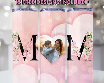 May include: Three pink insulated tumblers with a floral design and the letter "M". One tumbler features a photo of a mother and child inside a heart shape. The text "12 FREE DESIGNS INCLUDED" is at the top.