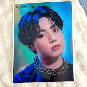 May include: A portrait print of a person with dark hair and a silver chain necklace. The person is wearing a black shirt and has a lip piercing. The background is a gradient of blue and green. The text "@_cbm_._dig" is in the upper left corner.