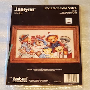 May include: A Janlynn counted cross stitch kit featuring a framed image of teddy bears. The kit includes the fabric, floss, and instructions. Finished size is 12" x 9" (30.5 x 22.9 cm).
