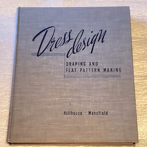May include: A gray book with the title "Dress Design: Draping and Flat Pattern Making" by Hillhouse and Mansfield.