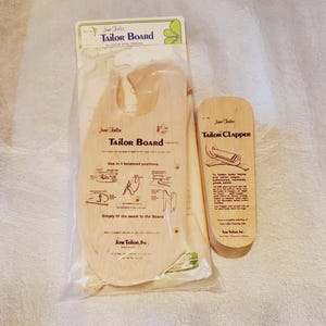 May include: A wooden tailor board and clapper set. The tailor board is in a plastic sleeve and has instructions printed on it. The clapper is a rectangular block of wood. Both items are made by June Tailor, Inc.