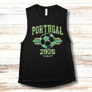 May include: Black sleeveless tank top displaying the brilliant rhinestone 'Portugal 2026' design. An ideal look for hot summer match days, featuring high-shine green and gold patriotic stones.