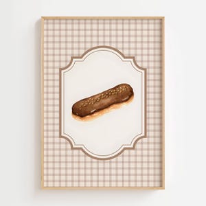 May include: A watercolour painting of a chocolate éclair with a brown glaze and sprinkled nuts, set against a white background within a decorative frame. The frame is set against a tan and white checked pattern, within a wooden frame.