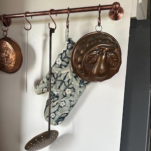 Estante para ollas de latón sin lacar hecho a medida con ganchos en forma de S.